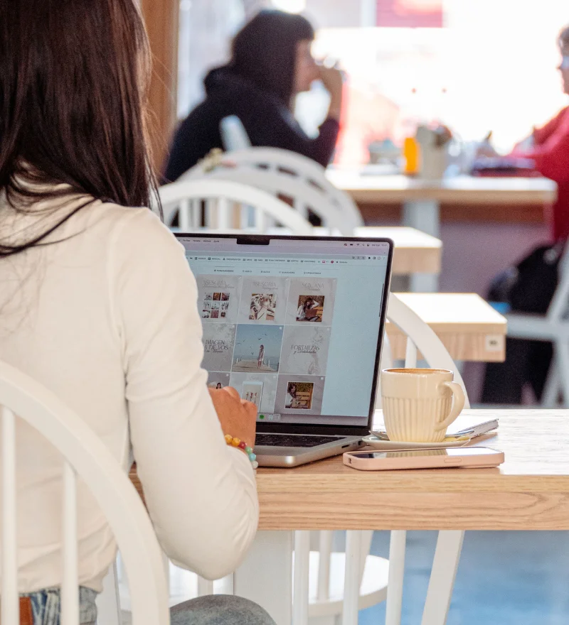 Kommunikation mit KI - Frau in einem Coworking Space vor einem Laptop.